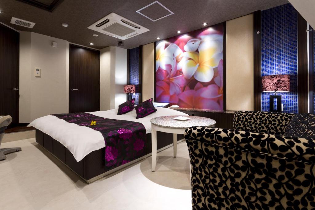 京都もしもしピエロ NEO 京都店的卧室配有一张床和一张桌子及椅子