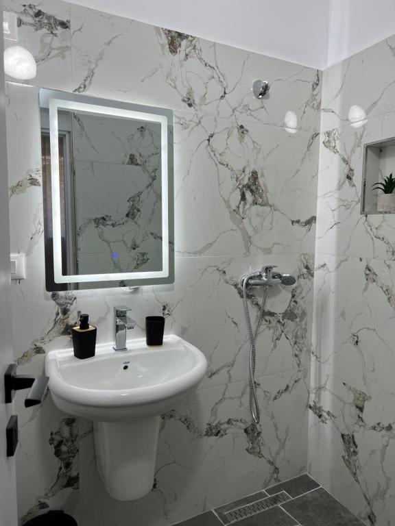 培拉特Nika's Guest House的白色的浴室设有水槽和镜子