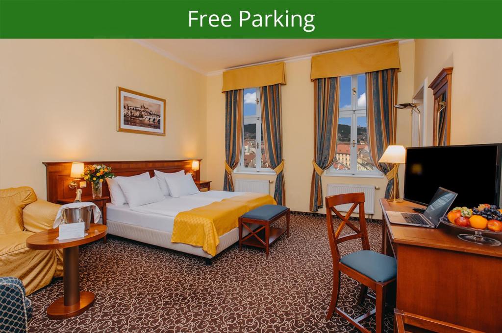布拉格路易斯传奇酒店的酒店客房配有一张床、一张书桌和一台电视。