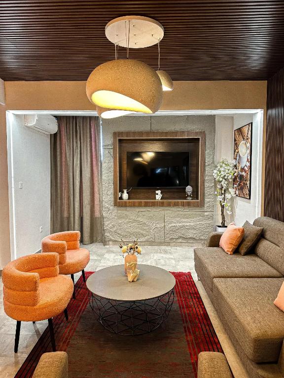 科托努Klik Klak Appart Hotel的客厅配有沙发和桌子