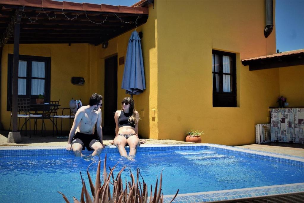 El RosarioGemütliches Ferienhaus in El Rosario mit Privatem Grill und Panoramablick的两个人坐在游泳池里