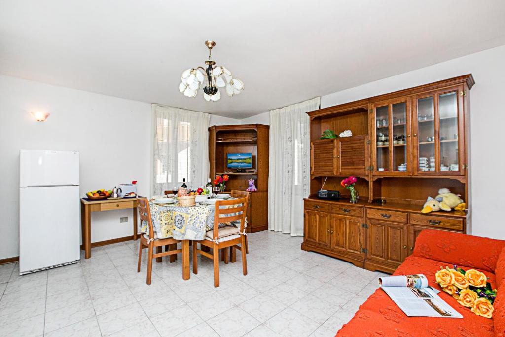 滕诺Cà Luisel 2的厨房以及带桌子和冰箱的客厅。