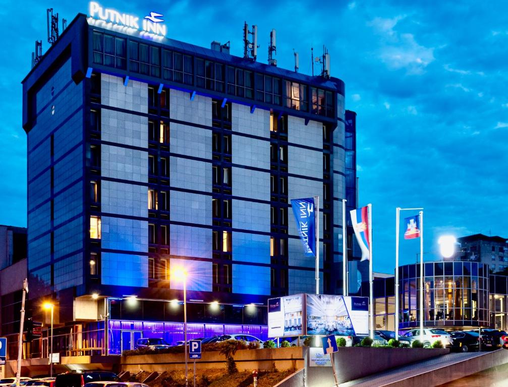 贝尔格莱德Putnik Inn Belgrade的建筑的侧面有蓝色的灯光