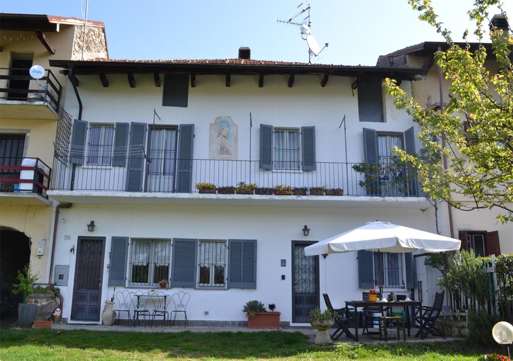 StropinoLa Ca' dal Canton的白色的房子,配有桌子和雨伞
