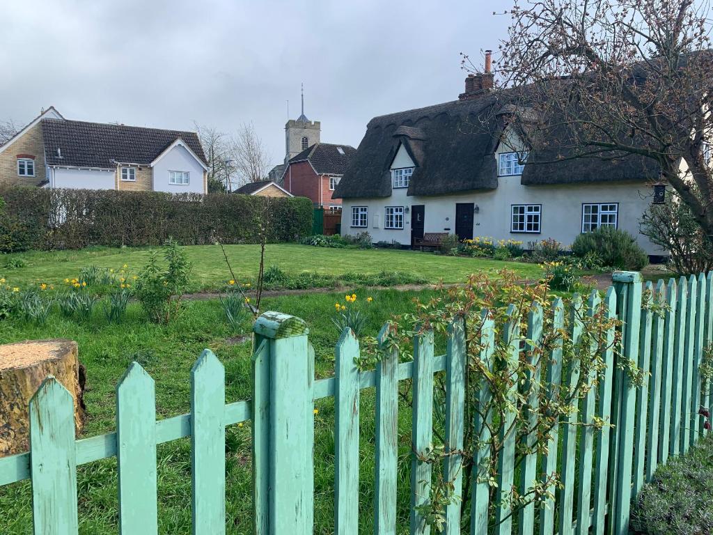 剑桥Beaumont's Cottage的白色房子前面的绿色围栏