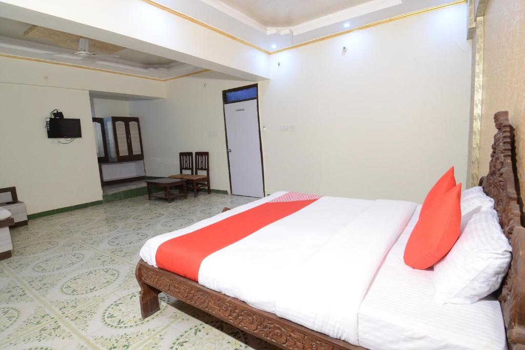 焦特布尔OYO Flagship Ranibagh Palace的一间卧室配有红色枕头的床