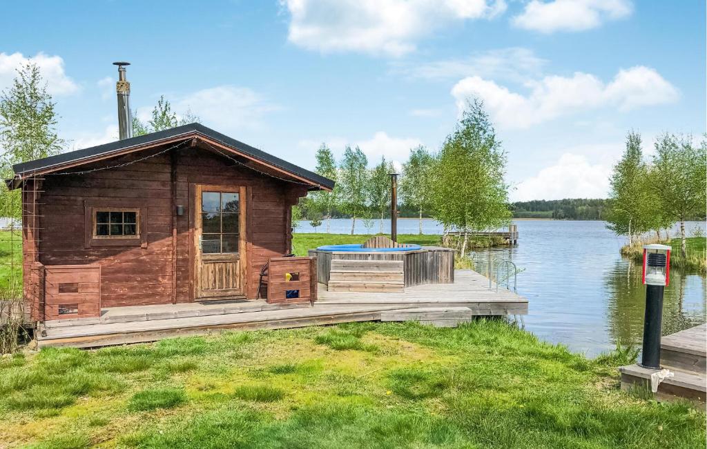 AspöNice Home In Strngns With 5 Bedrooms, Sauna And Wifi的湖上码头上的小木屋