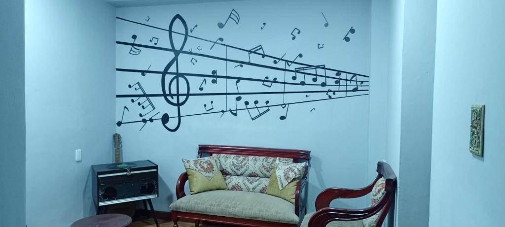 里奥班巴Suite Privada Riobamba的一间墙上配有椅子和音乐笔记的房间