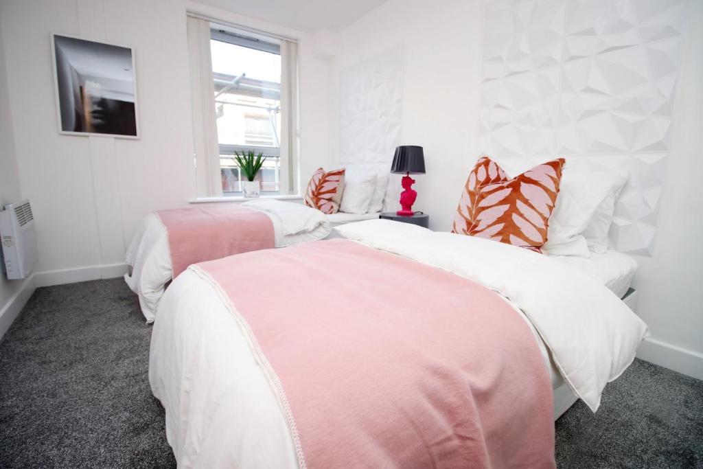 布里斯托2BR Near City centre的配有2张床的白色墙壁和窗户。