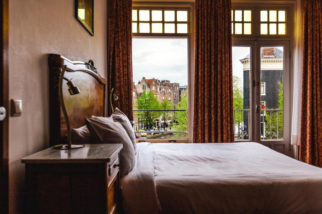 阿姆斯特丹阿姆斯特丹维赫曼酒店的一间卧室设有一张床和一个大窗户