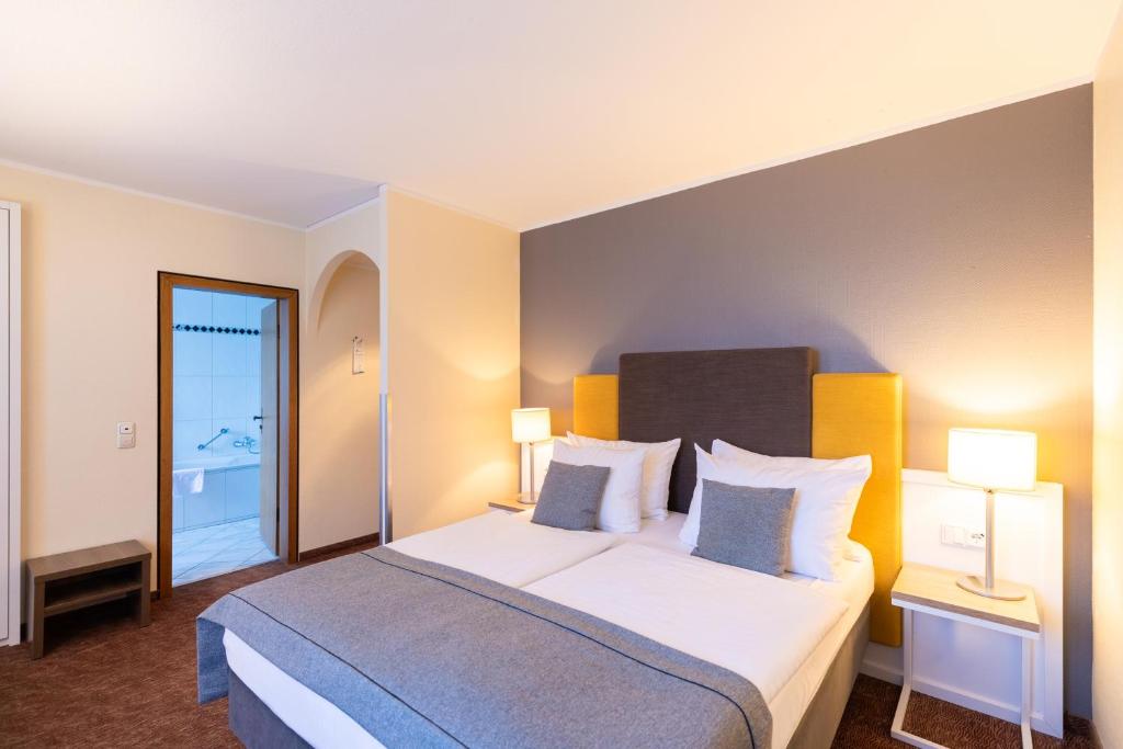 科隆Select Hotel Silence Garden Köln的酒店客房设有一张大床和两盏灯