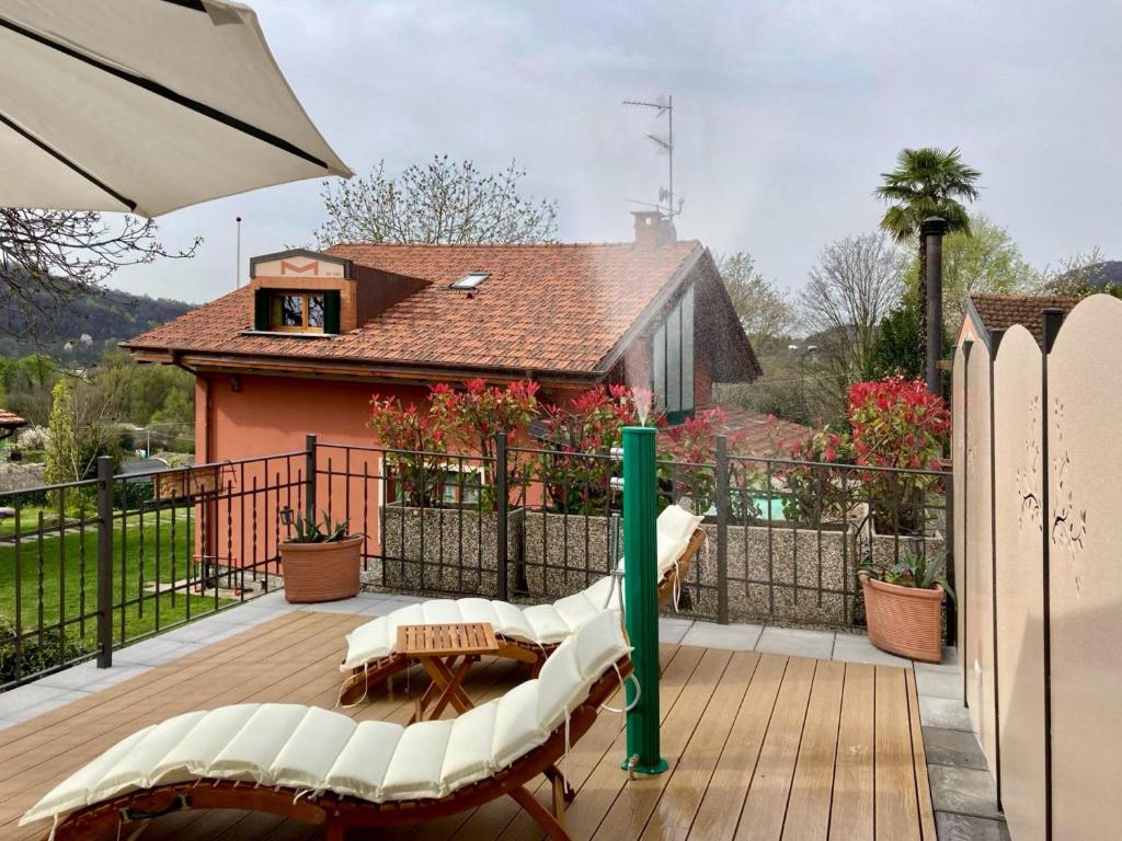 PisanoIl Gelsomino - Terrace Country House的一个带绿杆和椅子的甲板和一座房子