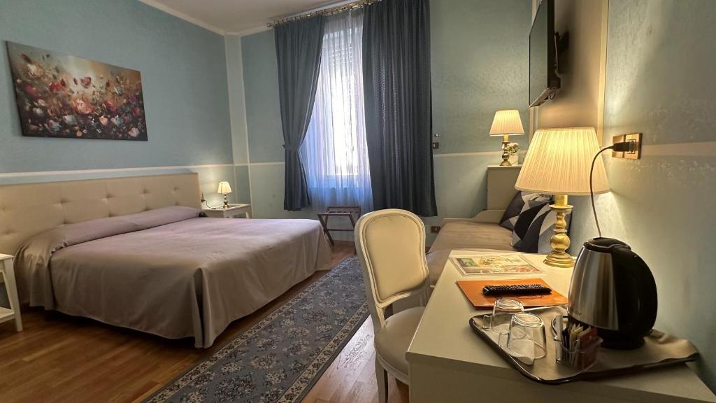 博洛尼亚罗马酒店的一间卧室配有一张床、一张桌子、一张床和一张沙发