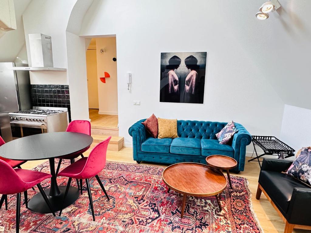 布雷达Gilly's Gallery的客厅配有蓝色的沙发和粉红色的椅子