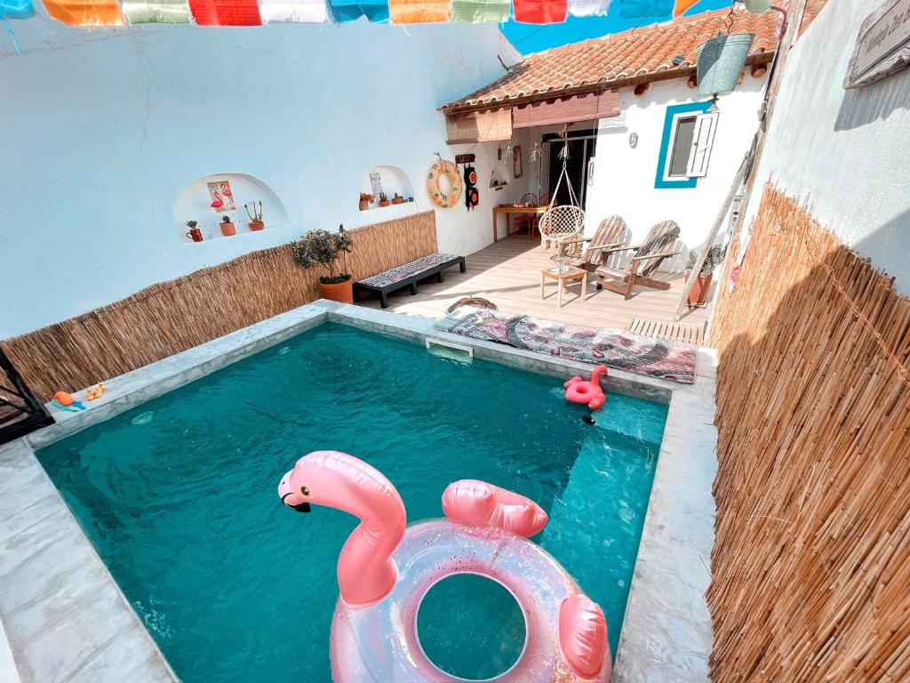 AlcariasAlentejo Zen BnB, Cozy suite, Patio, Private pool and entrance, Fire Pit的水中一个粉红色天鹅的游泳池