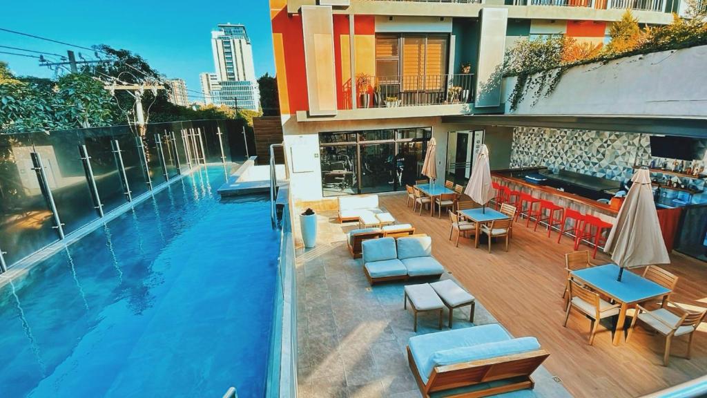 危地马拉Luxury Penthouse Guatemala zona 10的一座带桌椅的游泳池位于酒店大楼旁