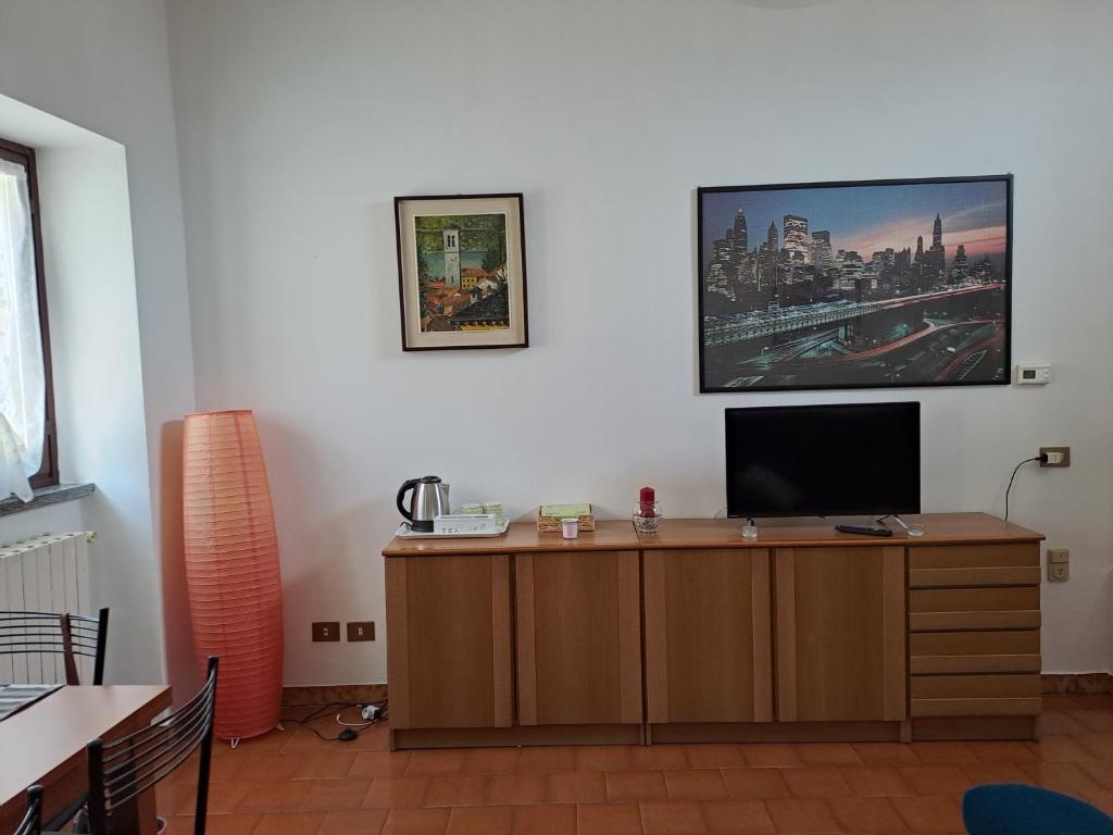 MagreglioMansardHouse zona Bellagio的一间设有一张桌子的房间,墙上有一台电视机