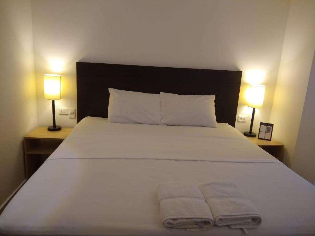 麦德林Hotel Medellin op的卧室配有一张带2条毛巾的大型白色床