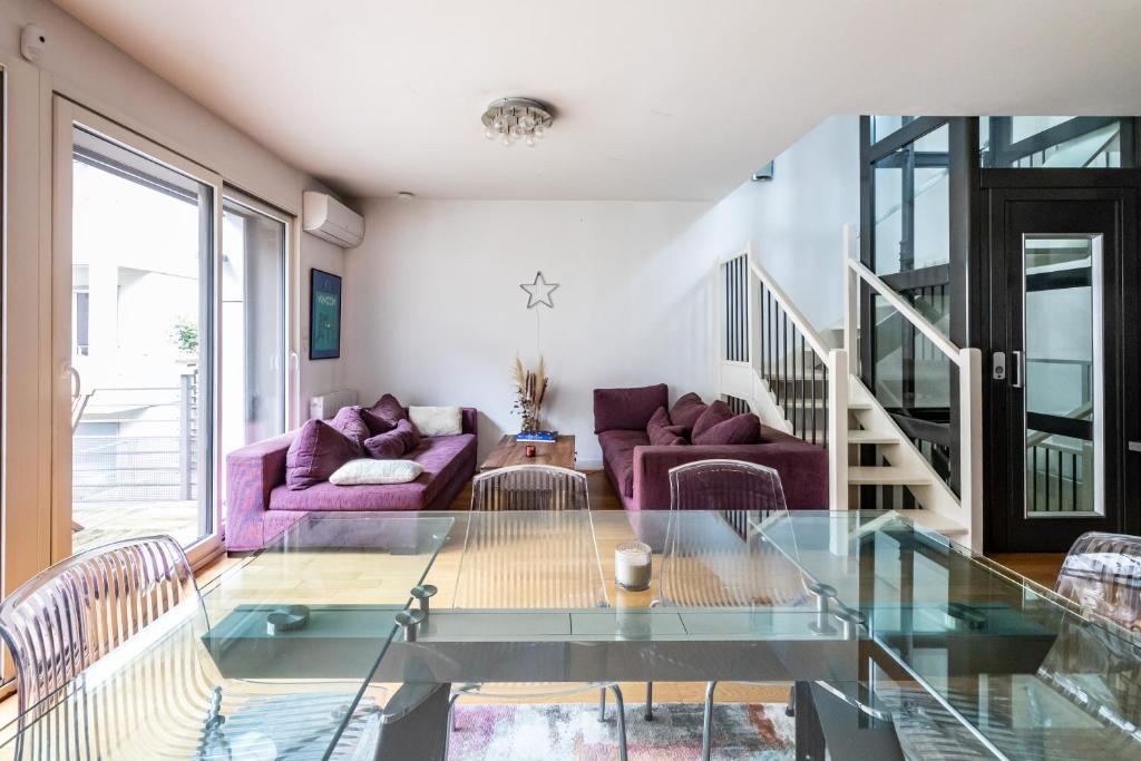 巴黎Villa Le Saint-Charles的客厅配有玻璃桌和紫色家具