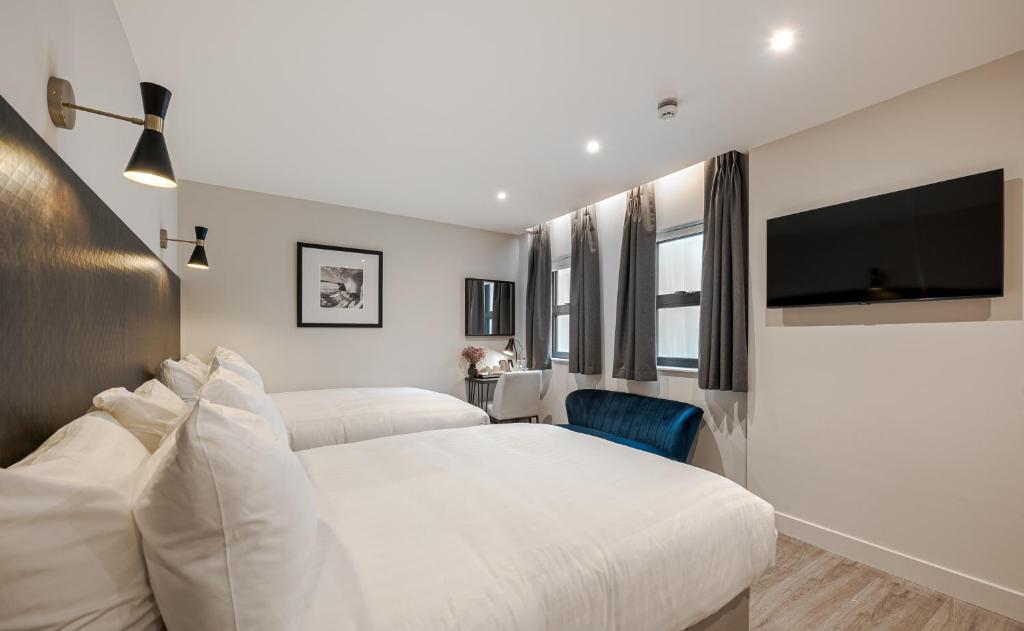 伦敦Kings Cross Express Hotel的一间卧室配有两张床和一台平面电视