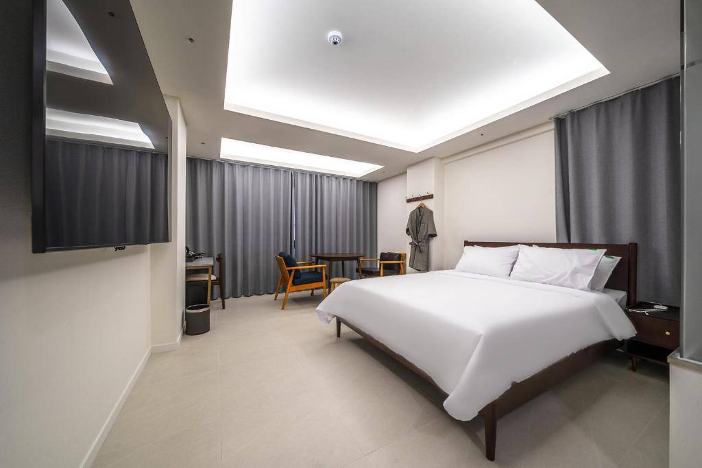 仁川市인천 연수 블루버드호텔 Bluebird Hotel的卧室配有一张白色大床