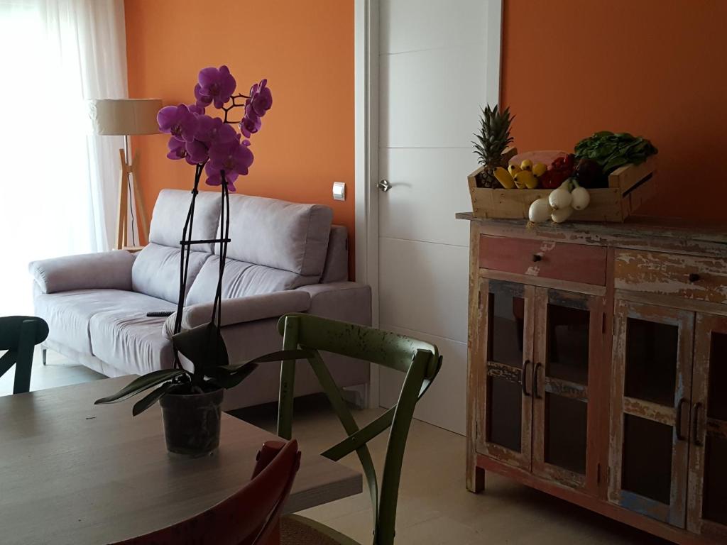 卡拉费尔Mandala apARTments的客厅配有一张带紫色花瓶的桌子