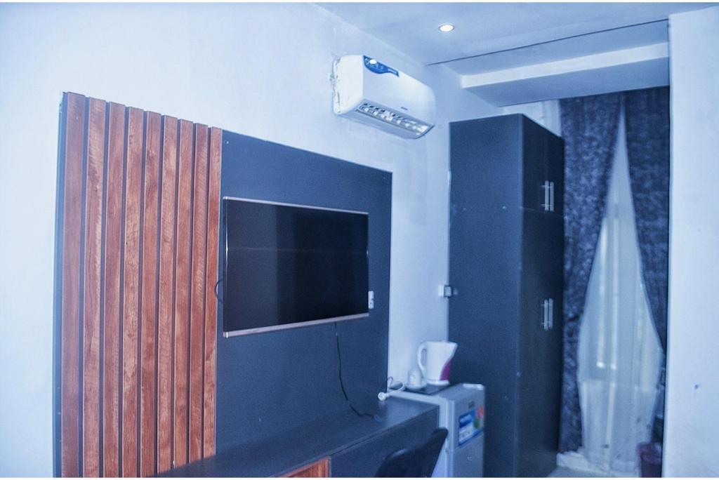 阿布贾Empire Suites And Apartment的配有电视和带电视的橱柜的客房