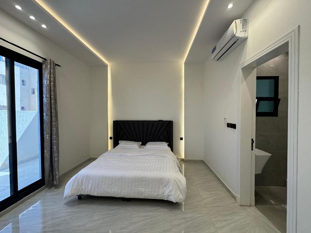 利雅德沙漠之梦Desert Dreams的卧室设有白色的床和大窗户