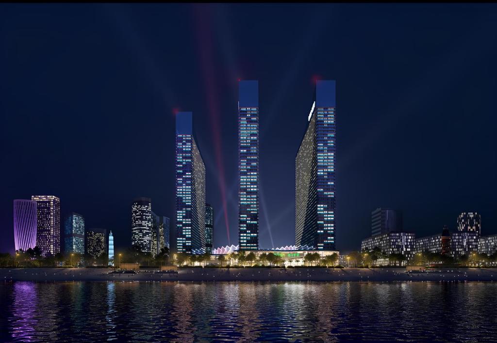 巴统Orbi City Sea View Aparthotel的一群高大的建筑在晚上在城市里