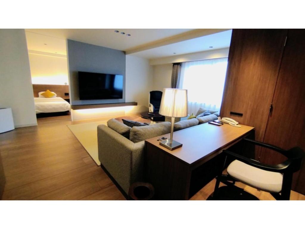 鸳泊Rishiri Fuji Kanko Hotel - Vacation STAY 63401v的客厅配有沙发和带台灯的书桌
