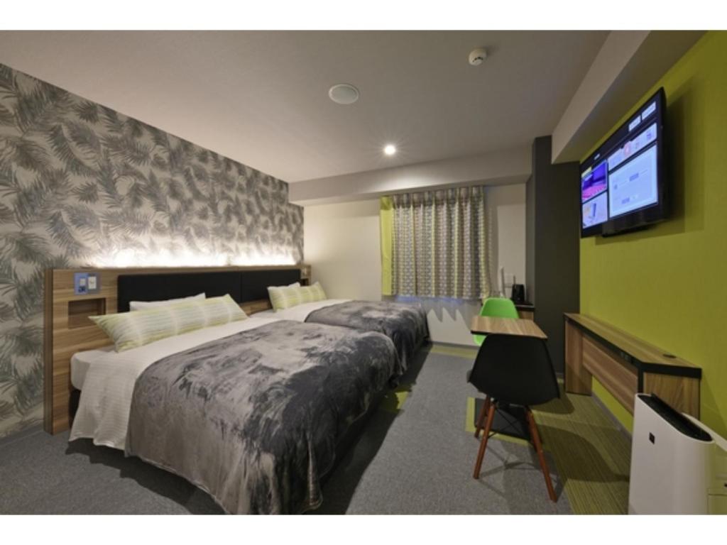 名户Green Rich Hotel Okinawa Nago - Vacation STAY 49920v的一间卧室配有一张大床和一台平面电视