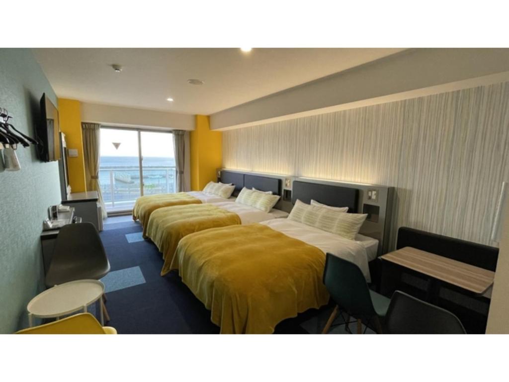 名户Green Rich Hotel Okinawa Nago - Vacation STAY 49879v的酒店客房内的一排床位