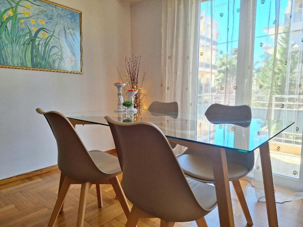 雅典Cozy apartment next to metro station的一间设有玻璃桌和椅子的用餐室