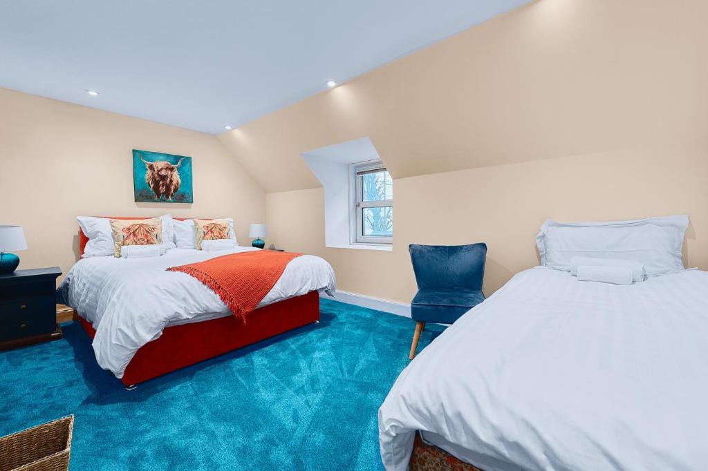 CononbridgeKinkell House B&B的蓝色地毯间内的两张床