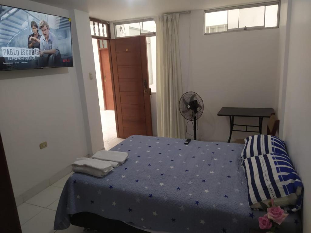 特鲁希略Ambigua Hospedaje的卧室配有一张床,墙上配有电视。