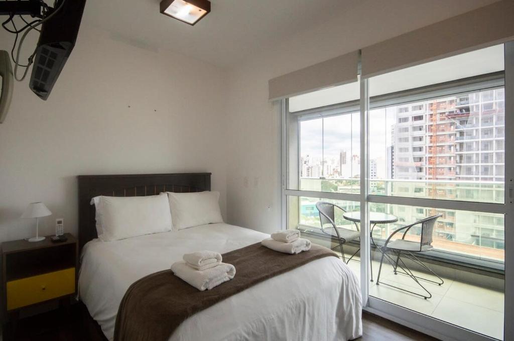 圣保罗BHomy Perdizes Vista do Allianz Parque TS808的一间卧室配有一张床,上面有两条毛巾