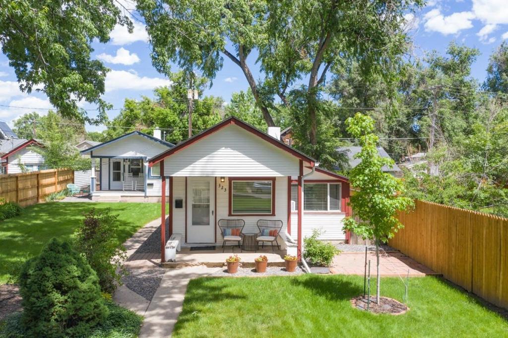科罗拉多斯普林斯Vintage Tiny House CUTE 1BDRM Big Appeal的一间白色的小小屋,在院子里设有围栏
