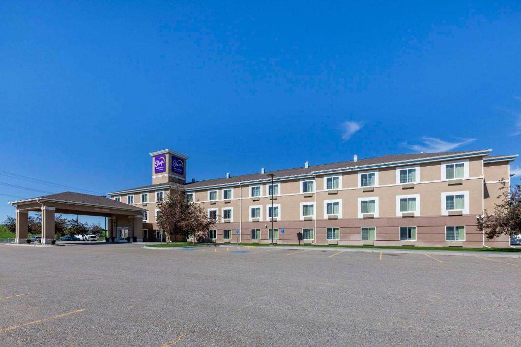 爱达荷福尔斯Sleep Inn & Suites Idaho Falls Gateway to Yellowstone的一座大型建筑,前面设有停车场