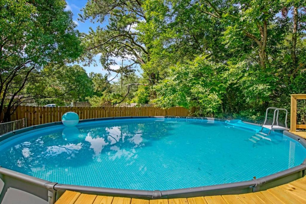 莫比尔Midcentury Modern - Pool & Hot tub - Retro Retreat的一个带木甲板和木栅栏的大型游泳池