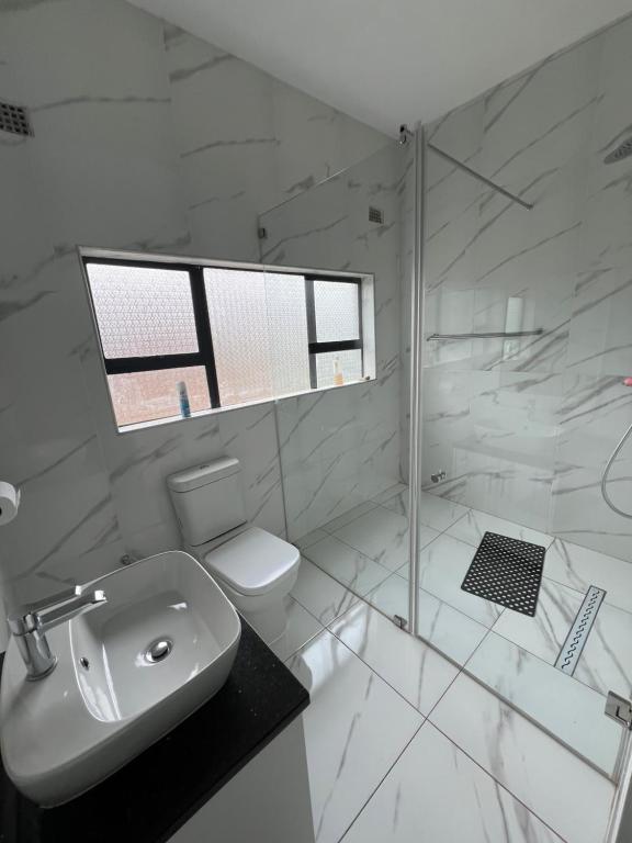 哈拉雷holiday villa的白色的浴室设有卫生间和淋浴。