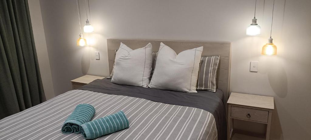 但尼丁Luxurious waterfront accommodation的一张带白色枕头的床和蓝色的物品