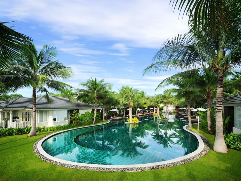 华欣华欣休养细节酒店的棕榈树庭院内的游泳池