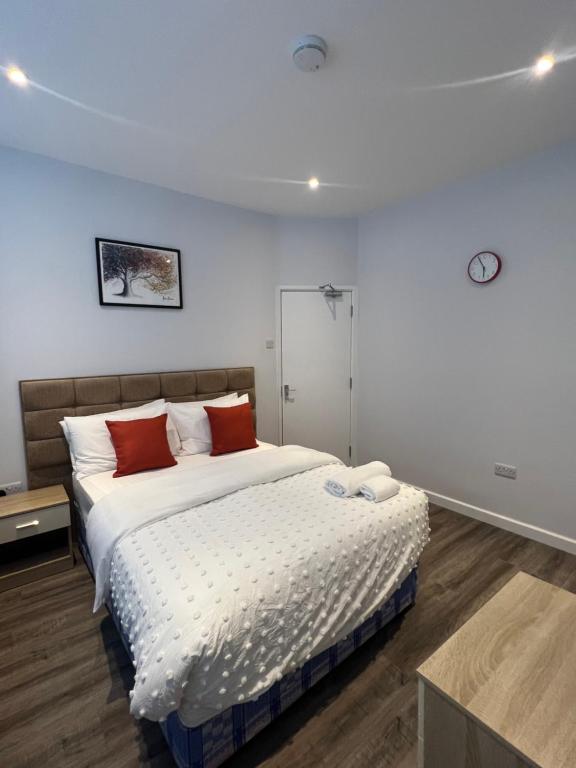 北安普敦Spencer bridge by AFL的一间卧室配有一张大床和两个红色枕头