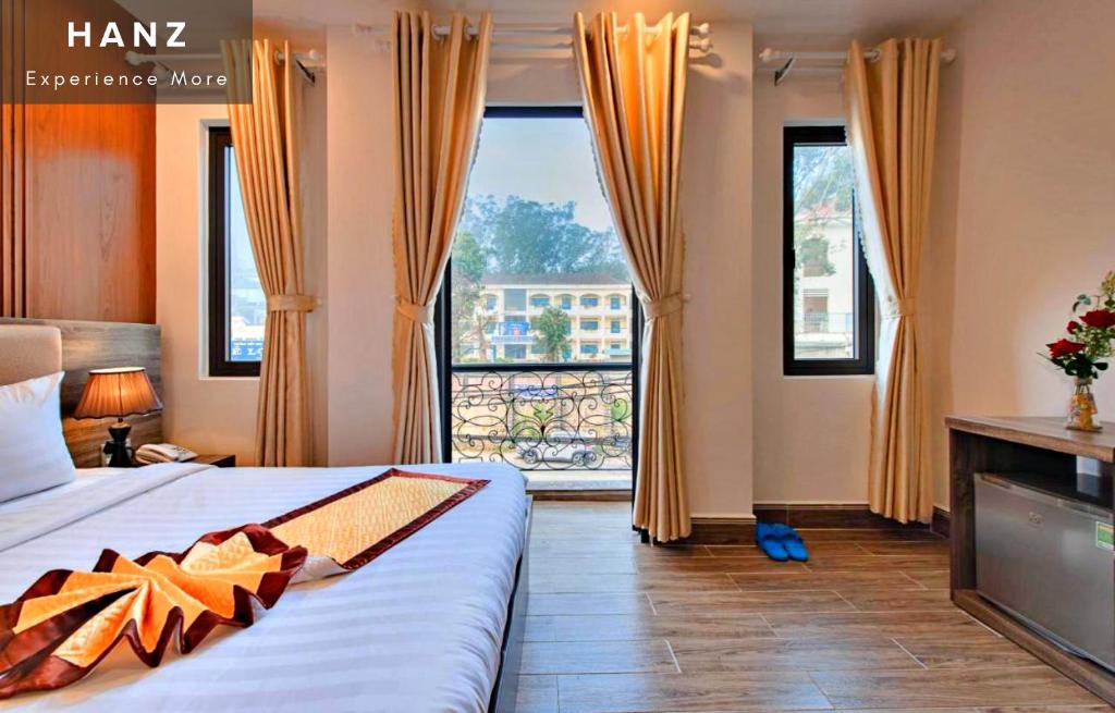 大叻HANZ Gia Hoang Hotel的酒店客房设有一张床和一个大窗户
