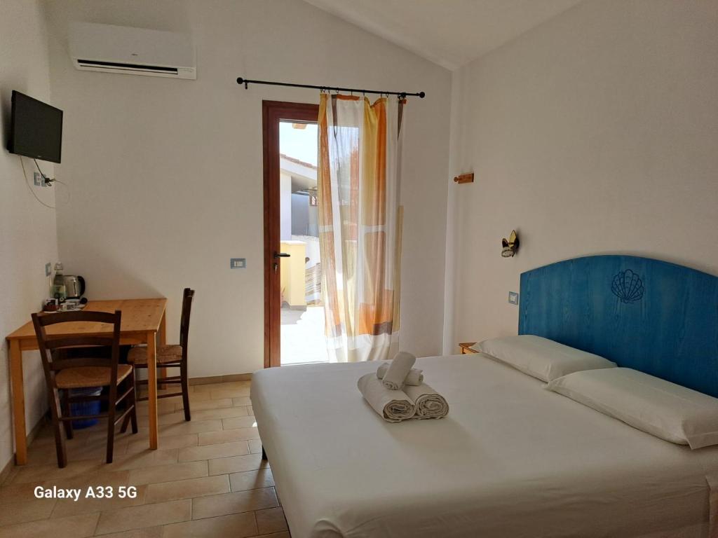 Funtana MeigaSa Cannizzada的一间卧室配有一张床铺和一张桌子,还有一间用餐室