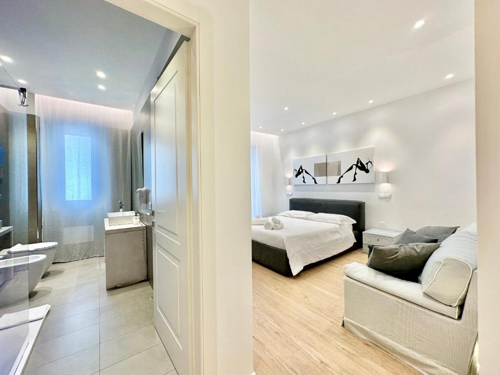 卡利亚里CeO LUXURY SUITE DI CAGLIARI的白色卧室配有床和沙发