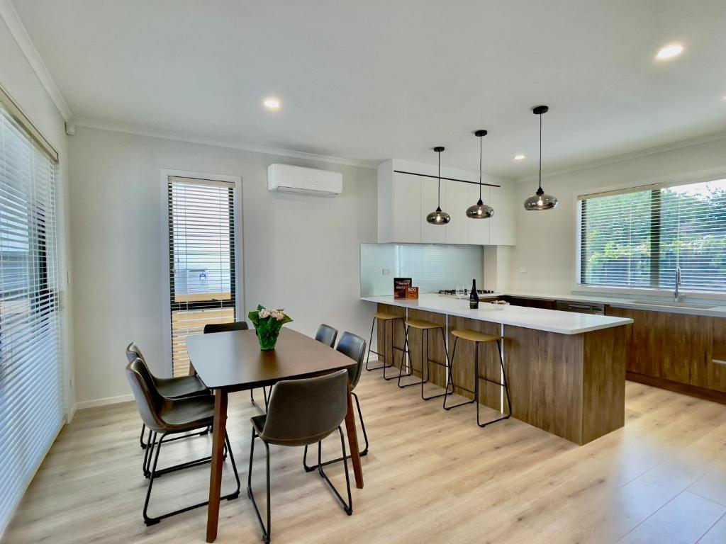 奥克兰Glendowie Brand-new comfortable 3 & 4-bedroom Houses的厨房配有桌椅和柜台。