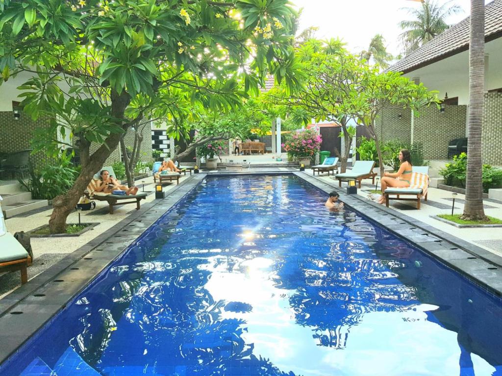 吉利特拉旺安松树别墅酒店的蓝色海水游泳池,度假村内的人