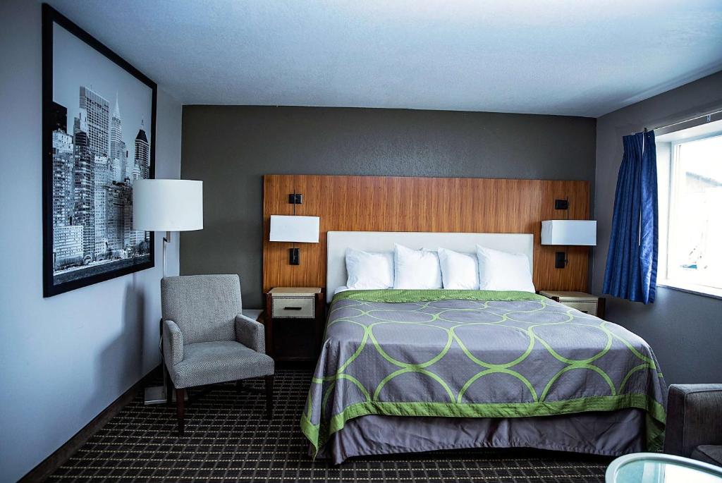 胡尔伯克Super 8 by Wyndham Holbrook的配有一张床和一把椅子的酒店客房