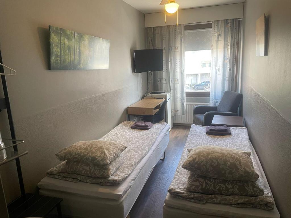 拉赫蒂玛卡考提帕特里亚旅馆的小房间设有两张床和椅子